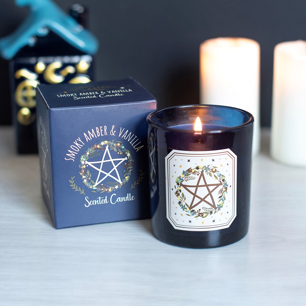 Vela perfumada acesa com embalagem preta e caixa azul