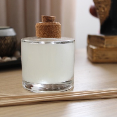 frasco de vidro com líquido branco e tampa de cortiça sobre mesa de madeira