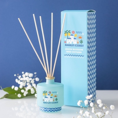Difusor de varetas aromáticas azul com embalagem azul e flores brancas