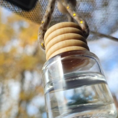 Frasco pequeno de vidro com tampa de madeira pendurado com cordão