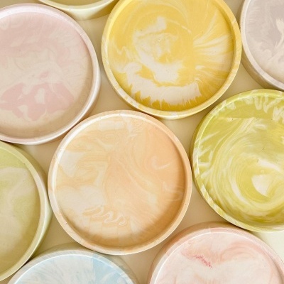 Pratos redondos com padrões marmorizados coloridos em tons pastel