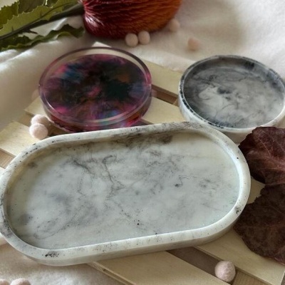 Três pratos decorativos de mármore e resina sobre base de madeira