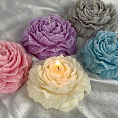 Cinco velas florais coloridas sobre tecido de cetim