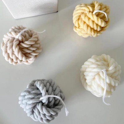 Quatro velas decorativas em espiral em vários tons sobre mesa branca