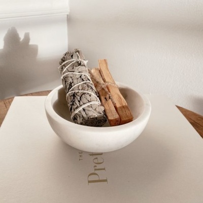 Vaso branco com ramos de madeira sobre livro branco