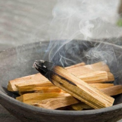 Paus de madeira com fumo numa tigela preta