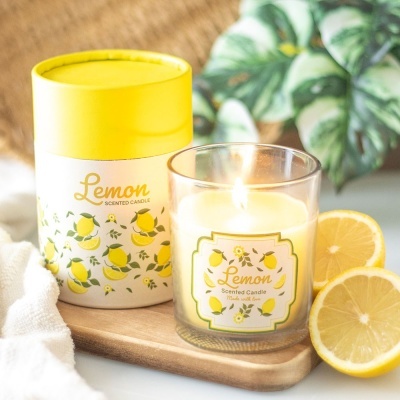 Vela perfumada de limão com embalagem e limões cortados