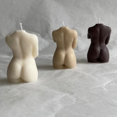 Três velas em forma de torso feminino em cores branco, bege e castanho escuro