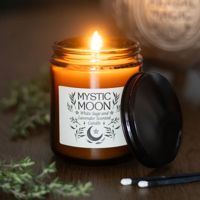 Vela aromática Mystic Moon acesa em frasco de vidro âmbar com tampa preta e rótulo branco
