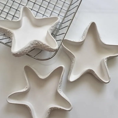 Três taças de cerâmica brancas em forma de estrela do mar com bordas texturizadas