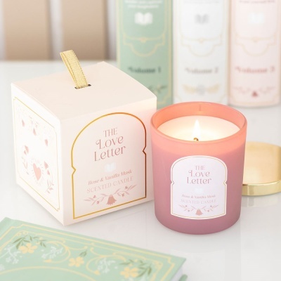 Vela perfumada rosa em copo de vidro com caixa branca e decoração elegante