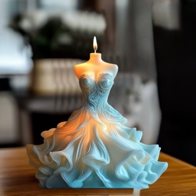 Vela decorativa forma de corpo feminino com vestido esvoaçante azul claro, acesa