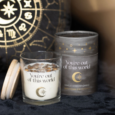 Vela aromática com cristais em copo de vidro e embalagem preta com tema celestial.
