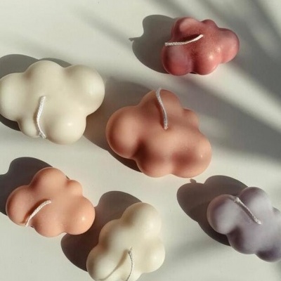 Velas em forma de nuvem em várias cores sobre superfície branca