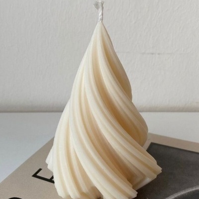 Vela branca espiralada sobre páginas de papel com texto, fundo claro