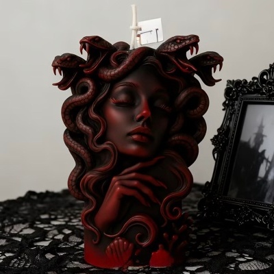 Vela decorativa de rosto feminino com cabelos de serpentes em preto e vermelho