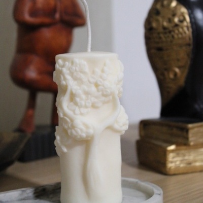 Vela branca com motivo de uvas em relevo sobre base de mármore