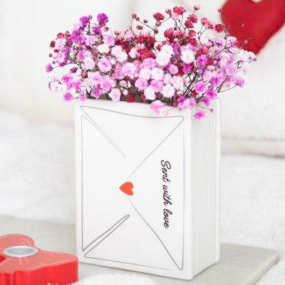 Vaso em forma de envelope branco com flores secas coloridas e texto Sent with love