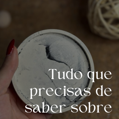 Mão segurando objeto circular cinza com textura, fundo com bola decorativa clara