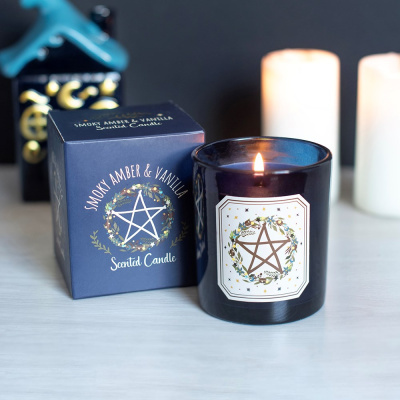 Vela perfumada acesa com embalagem preta e caixa azul