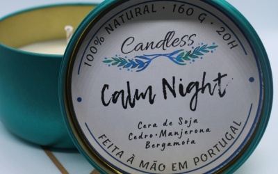 Vela aromática em lata metálica verde-azulada com tampa branca e texto impresso