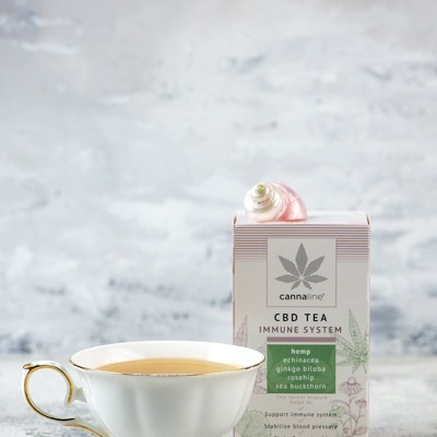 Chávena de chá branca com chá ao lado de caixa de chá CBD Tea Immune System Cannaline