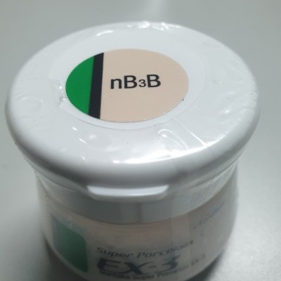 Frasco branco pequeno com etiqueta 'nB3B' na tampa