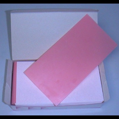 Caixa aberta com peças retangulares cor-de-rosa de borracha