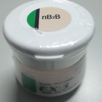 Pote branco pequeno com tampa e etiquetas de texto em superfície cinza