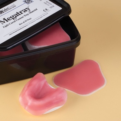 Material de molde rosa em recipiente preto com peças moldadas ao lado