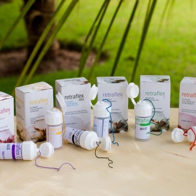 Produtos Retraflex com embalagens e dispositivos plásticos com fios coloridos sobre mesa clara