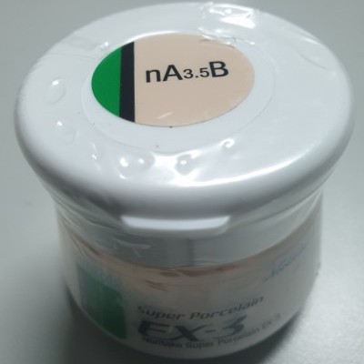 Frasco branco pequeno com tampa rotulada contendo produto para porcelana.