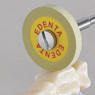 Disco abrasivo amarelo com texto 'EDENTA' sobre prótese dentária branca