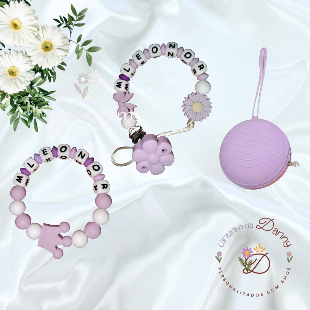 Duas pulseiras de silicone lilás e branco com nomes e pendentes, e um porta-moedas redondo lilás sobre fundo branco e flores