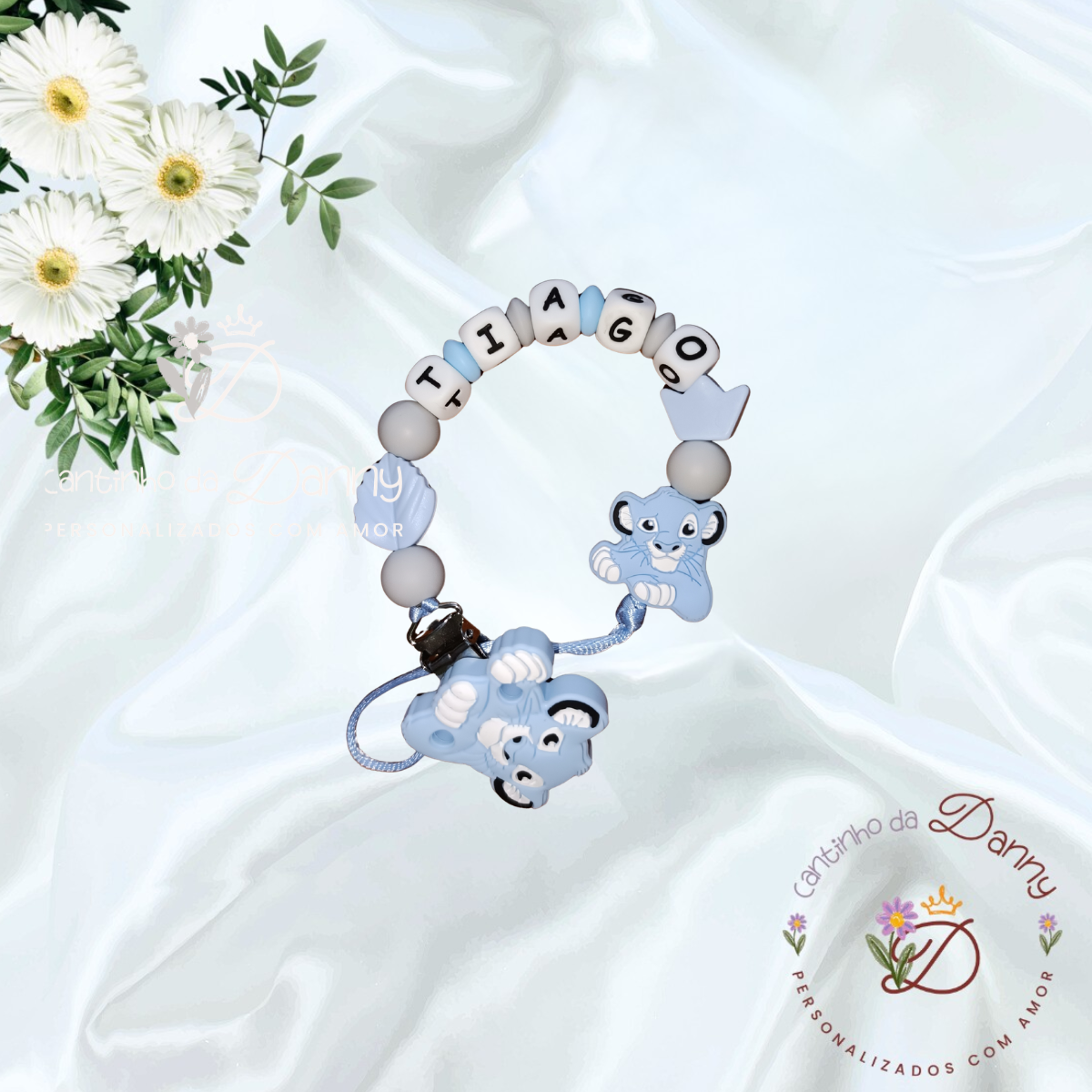 Pulseira personalizada azul com nome TIAGO, conta de personagem Simba e decoração floral sobre fundo branco