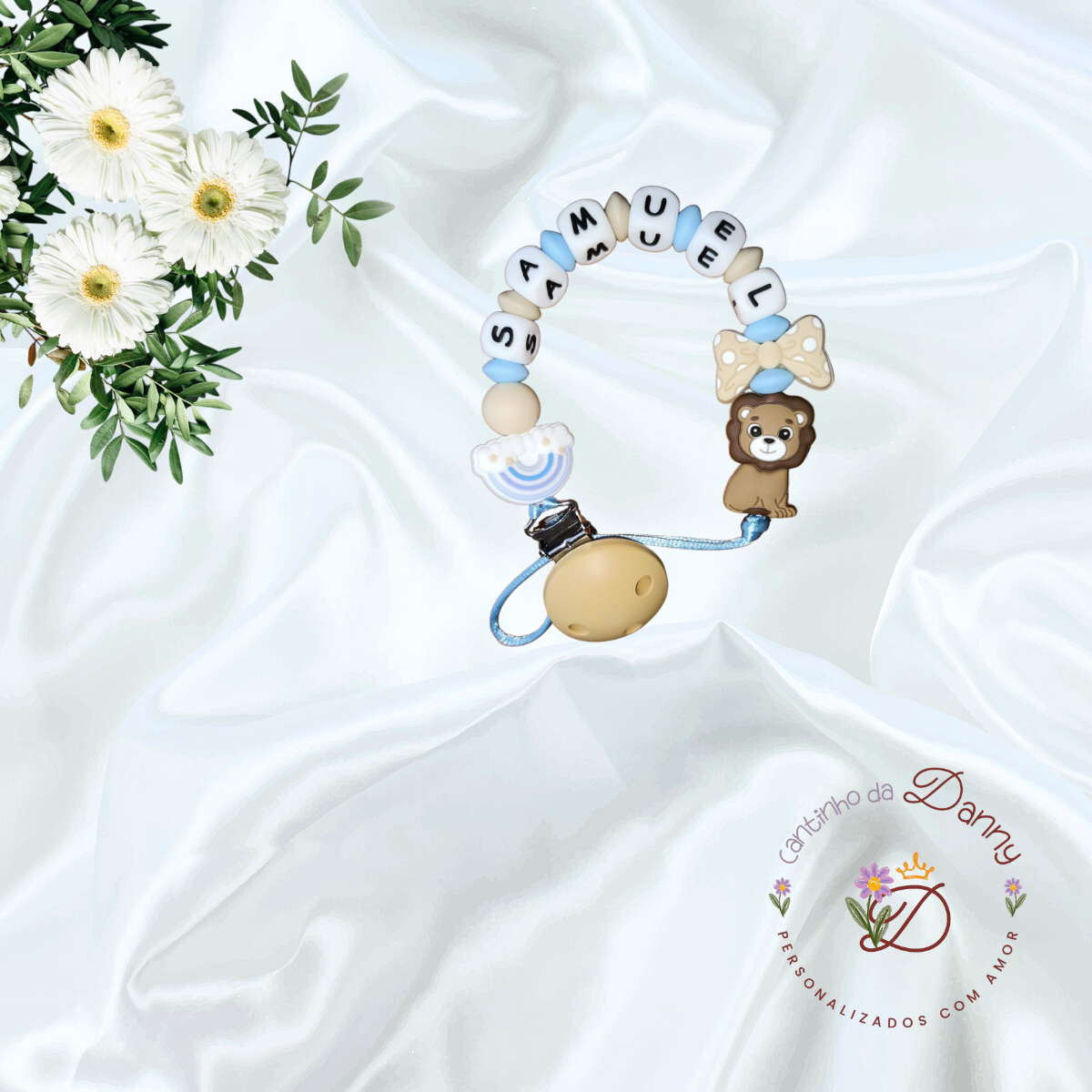 Prendedor de chucha com nome SAMUEL, leão, laço e arco-íris em fundo branco com flores