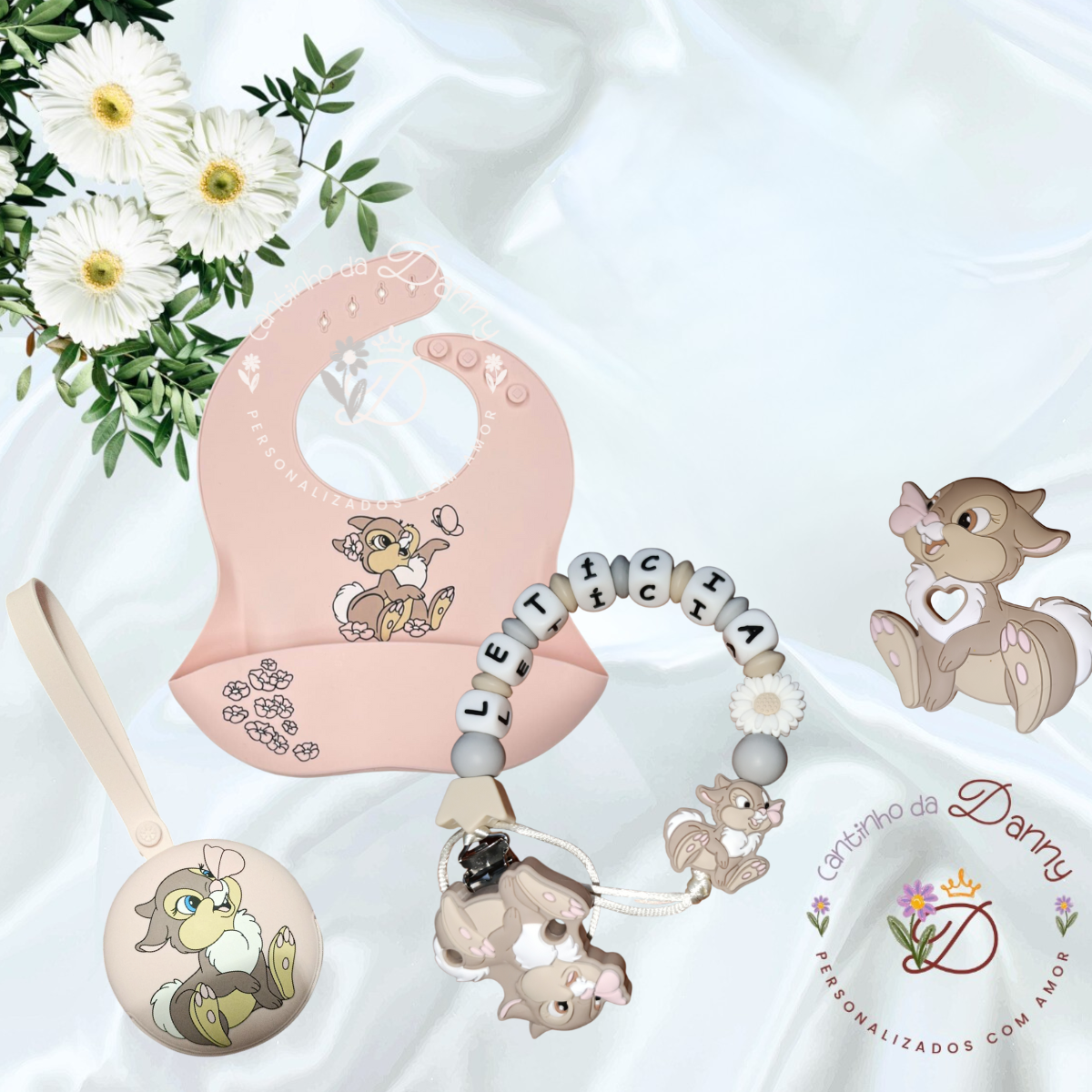 Conjunto para bebé com babete de silicone rosa, porta-chupeta redondo e presa-chupeta com nome LETICIA, decorados com personagens de animação castanhos e bege.