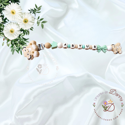 Prendedor de chucha com nome Artur e leões em fundo branco com flores