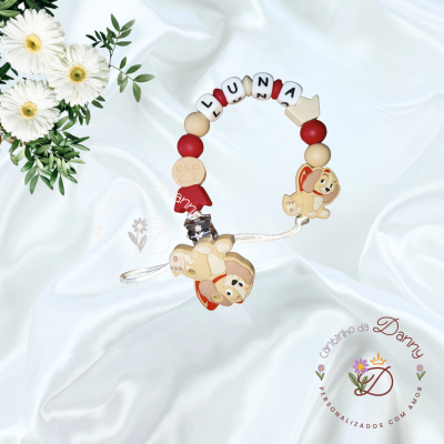 Prendedor de chupeta personalizado com contas e figuras de cão em fundo branco e flores.
