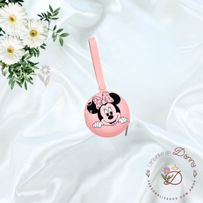 Estojo redondo rosa em silicone com imagem da Minnie Mouse e alça, sobre fundo branco com flores e logótipo