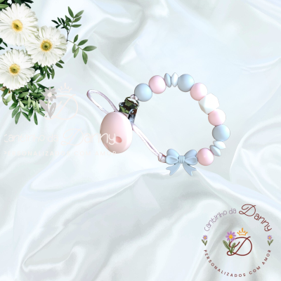 Prendedor de chupeta com contas de silicone rosa e azul em fundo branco.