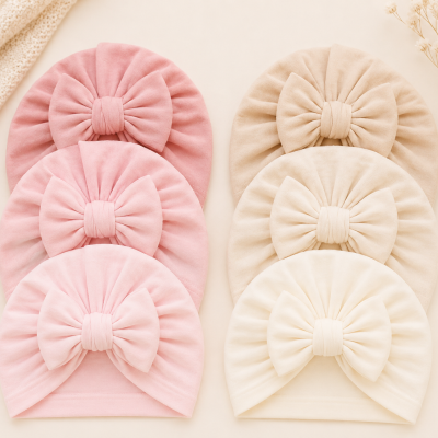 Seis toucas para bebé com laços grandes em tons rosa e bege