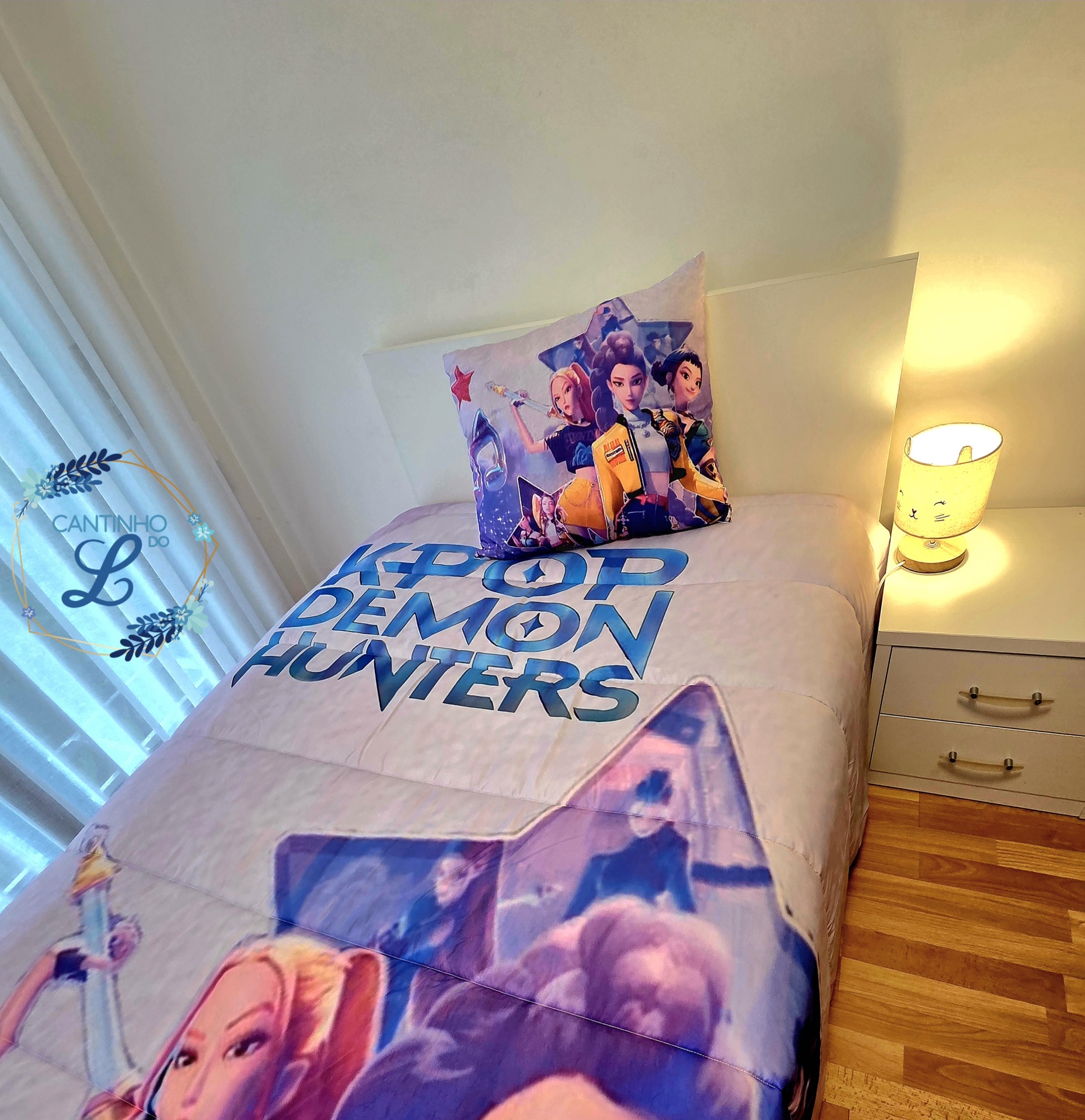 Edredão K-Pop com Estampagem Digital – Roupa de Cama Juvenil Cama com edredão e almofada K-POP DEMON HUNTERS decorados com personagens animados em quarto com mesa de cabeceira e candeeiro.