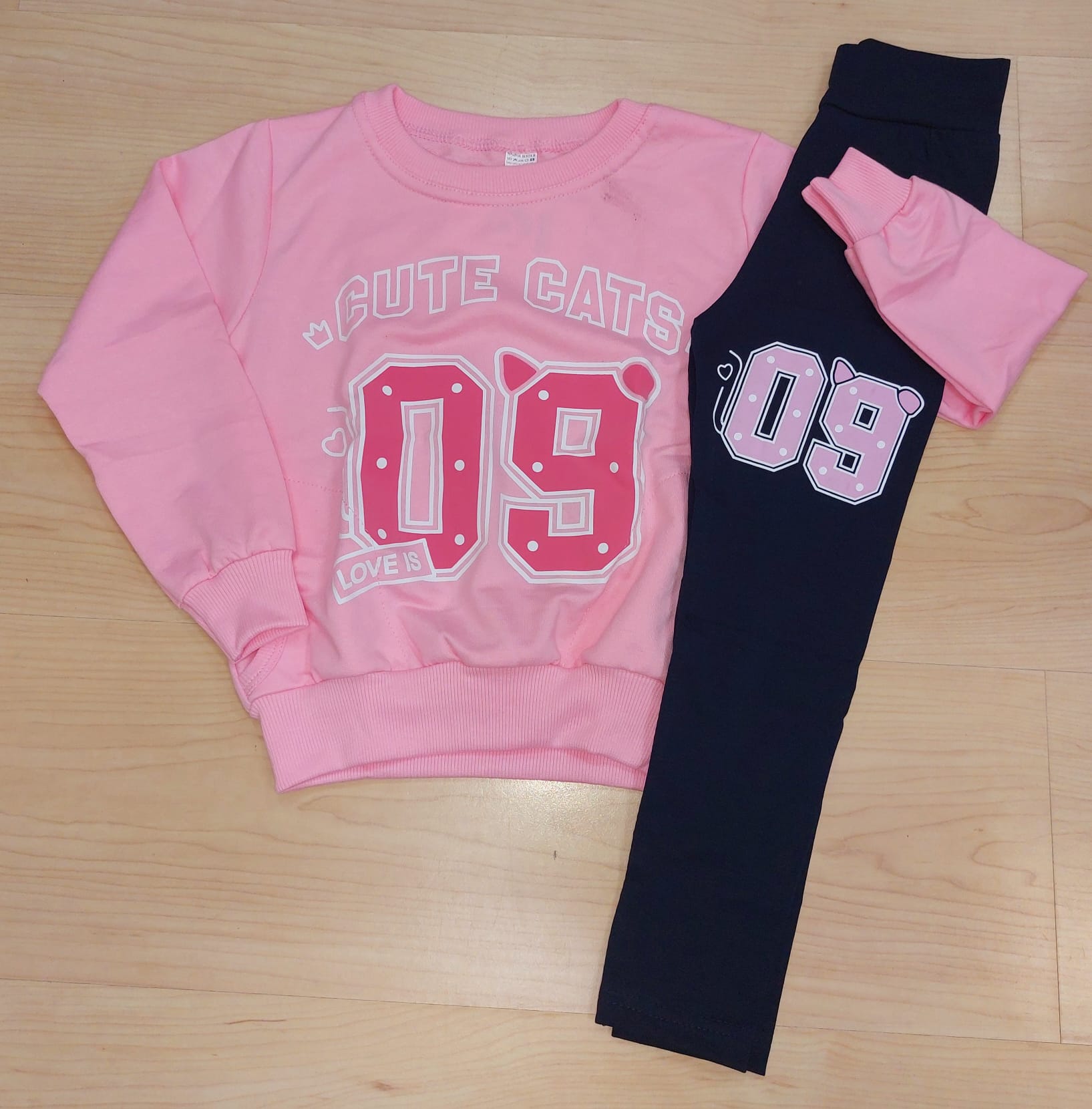 Conjunto Menina “Cute Cats 09” – 4 aos 14 Anos | Primavera Verão Conjunto infantil com sweatshirt rosa e leggings pretas com estampados numéricos e texto