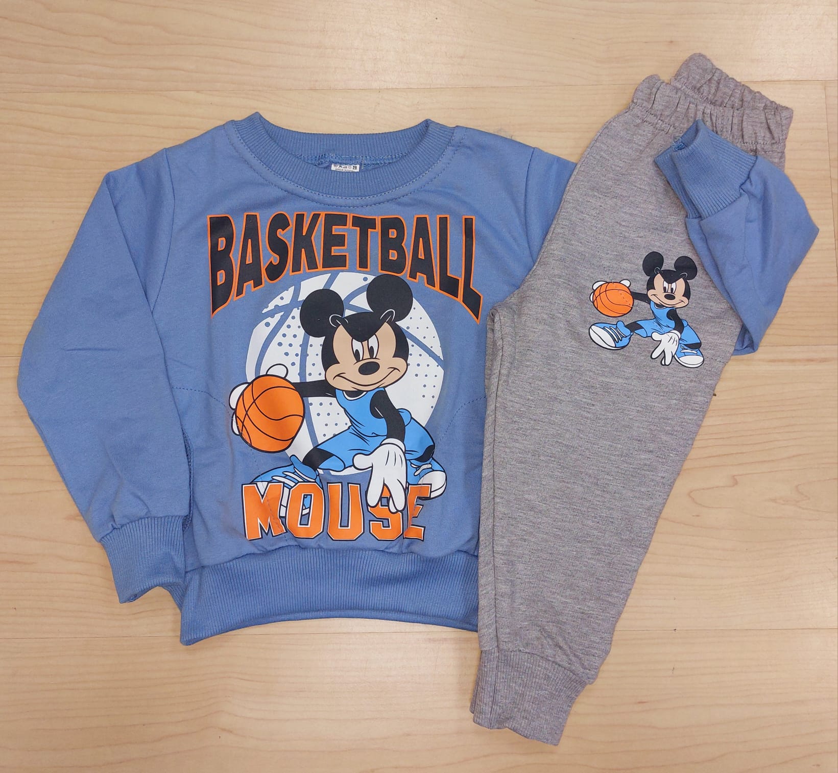 Conjunto Mickey Menino Basketball – Primavera Verão (Sem Carda) | 1 aos 8 Anos Conjunto de roupa infantil azul e cinza com Mickey Mouse a jogar basquetebol.