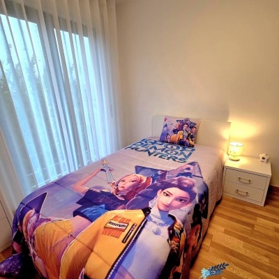 Edredão e fronha de cama infantil com motivos de personagens animados e texto DEAR DEMON HUNTERS