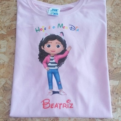T-shirt rosa com estampa de personagem e texto em português