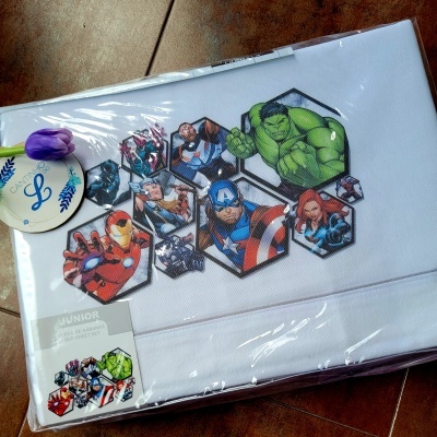 Jogo de cama infantil branco com estampado dos Avengers em hexágonos e embalagem de plástico