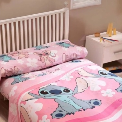 Roupa de cama cor-de-rosa com personagens Disney Stitch em quarto infantil com móveis brancos.