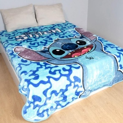 Manta azul com estampa do personagem Stitch sobre cama branca em quarto simples